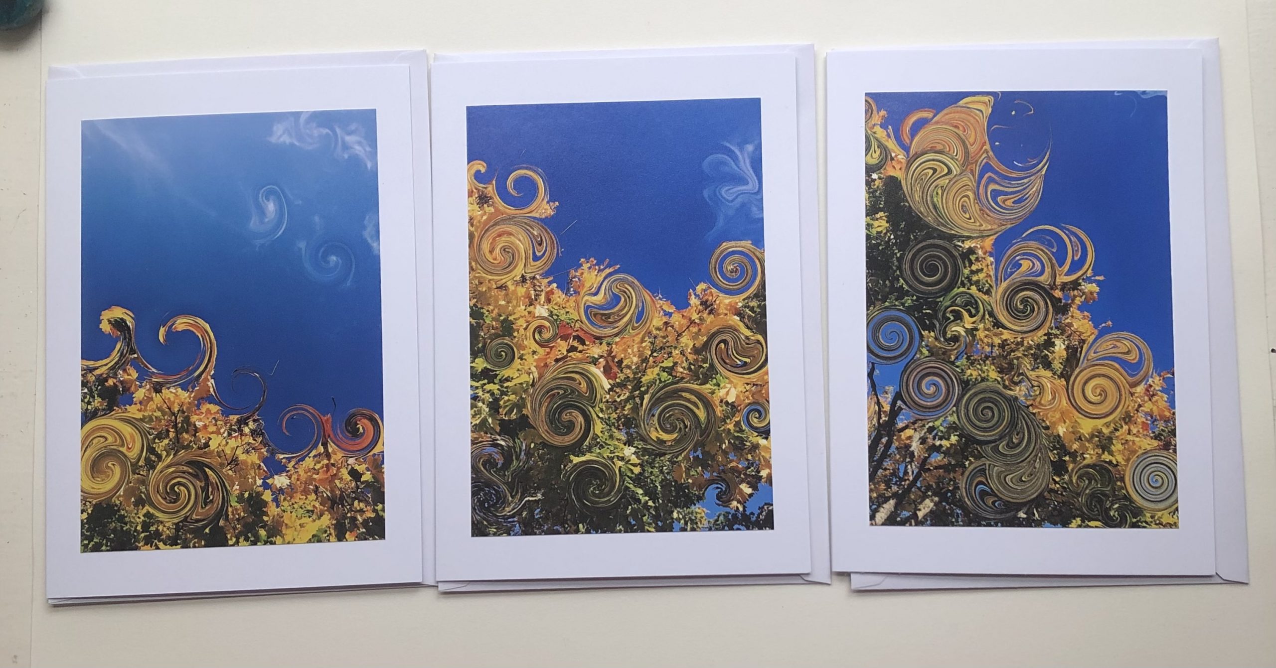 Handmade greeting cards 7x5" with photo print of tree tops with digitally created swirls in leaves. Blue skies, autumn colour leaves from photography of local nature.